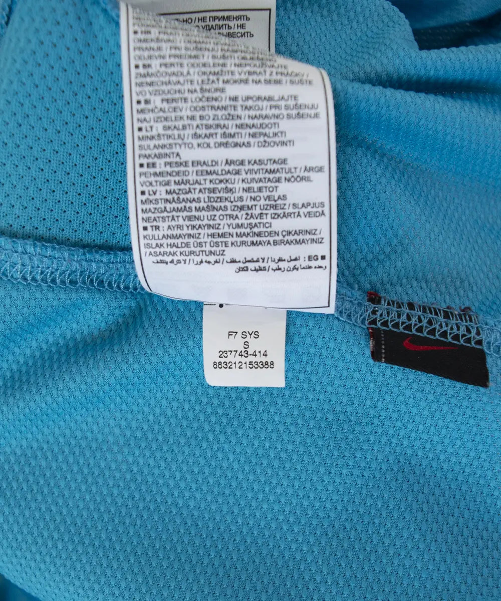 Maillot extérieur vintage bleu et jaune du FC Barcelone de la saison 2007-2009. On peut retrouver le sponsor unicef et l'équipementier nike. Le maillot est floqué du numéro 19 Messi. On peut voir sur cette photo l'étiquette du maillot comportant les numéros 237743-414