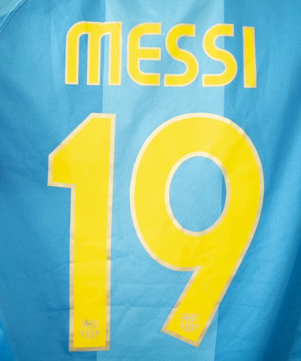 Maillot extérieur vintage bleu et jaune du FC Barcelone de la saison 2007-2009. On peut retrouver le sponsor unicef et l'équipementier nike. Le maillot est floqué du numéro 19 Messi