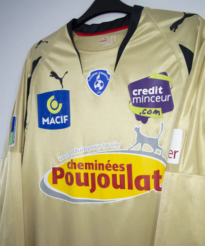 Maillot vintage extérieur doré de niort lors de la saison 2007-2008. On peut retrouver l'équipementier puma et le sponsor cheminées poujoula. Le maillot a été porté par Morisot lors d'un match en Ligue 2