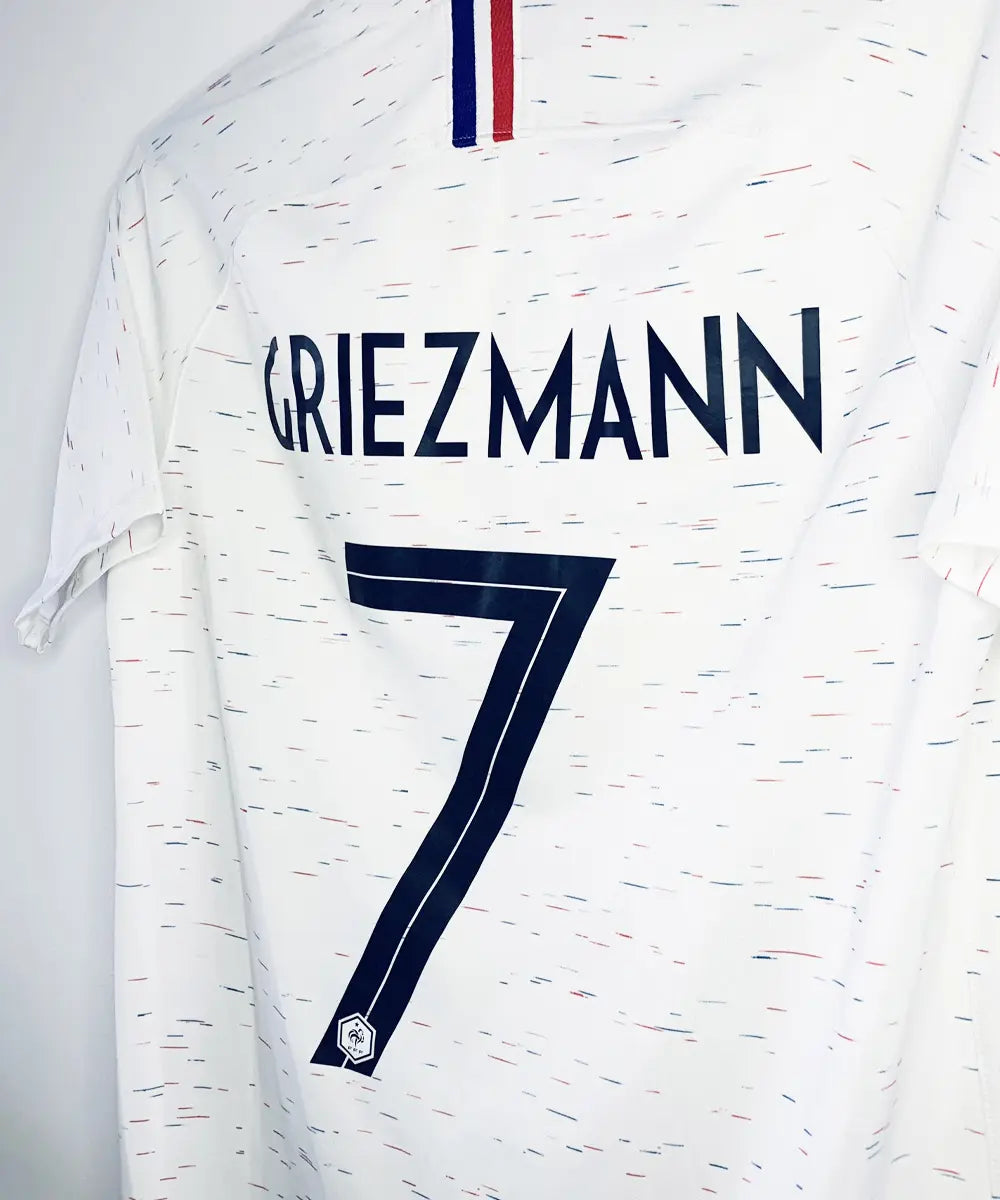 Maillot vintage extérieur blanc de l'Equipe de France 2018. On peut retrouver l'équipementier nike. Le maillot est floqué du numéro 7 Griezmann