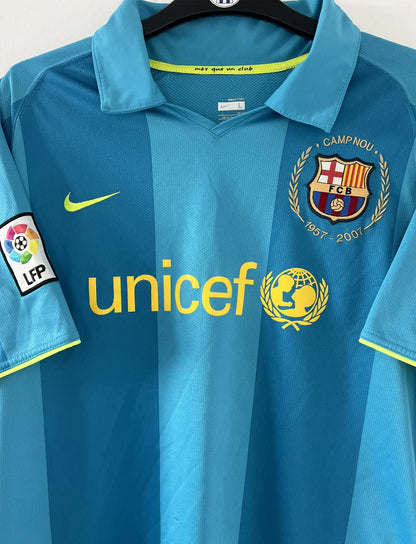 Maillot de foot vintage extérieur du FC Barcelone de la saison 2007-2009. On peut retrouver l'équipementier nike et le sponsor unicef. Le maillot est de couleur bleu turquoise. Il s'agit d'un maillot authentique comportant les numéros 237743-414