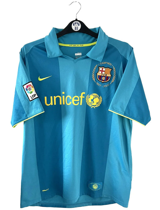 Maillot de foot vintage extérieur du FC Barcelone de la saison 2007-2009. On peut retrouver l'équipementier nike et le sponsor unicef. Le maillot est de couleur bleu turquoise. Il s'agit d'un maillot authentique comportant les numéros 237743-414