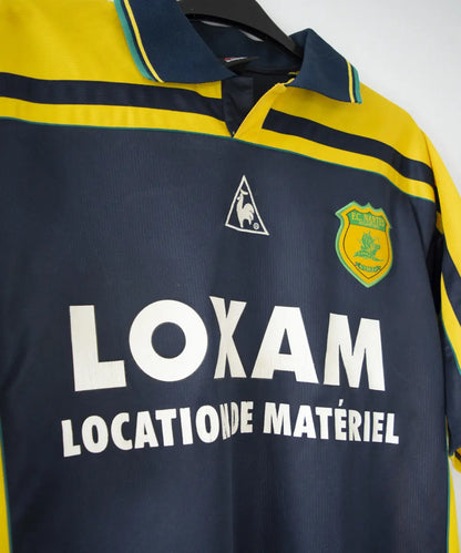 maillot de foot du fc nantes noir et jaune de la saison 2000-2001. On peut retrouver l"équipementier le coq sportif. On peut aussi retrouver à l'avant du maillot le sponsor loxam