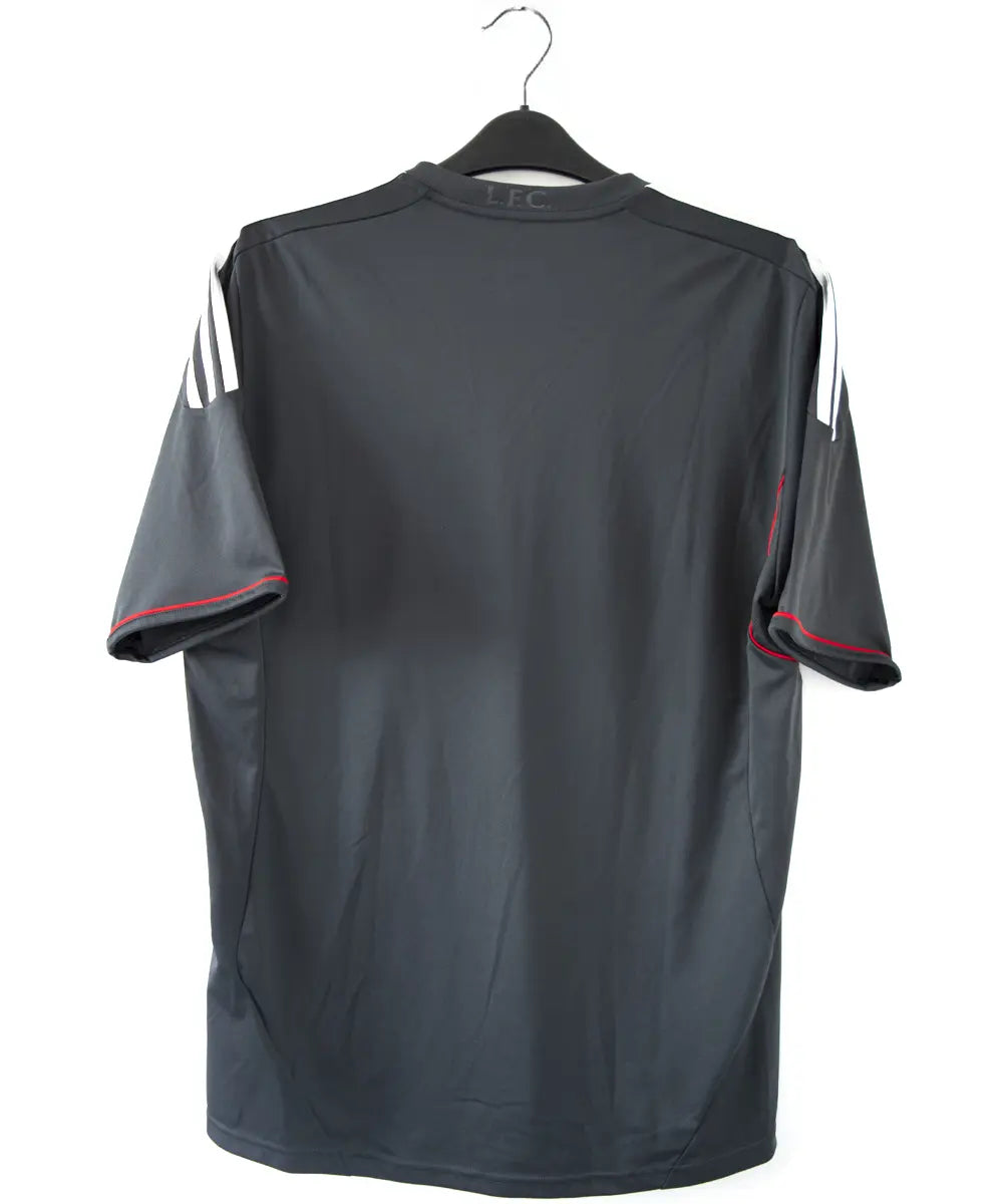 Maillot extérieur de liverpool de la saison 2011-2012. Le maillot est de couleur noir, gris et rouge. On peut retrouver l'équipementier adidas et le sponsor standard chartered.