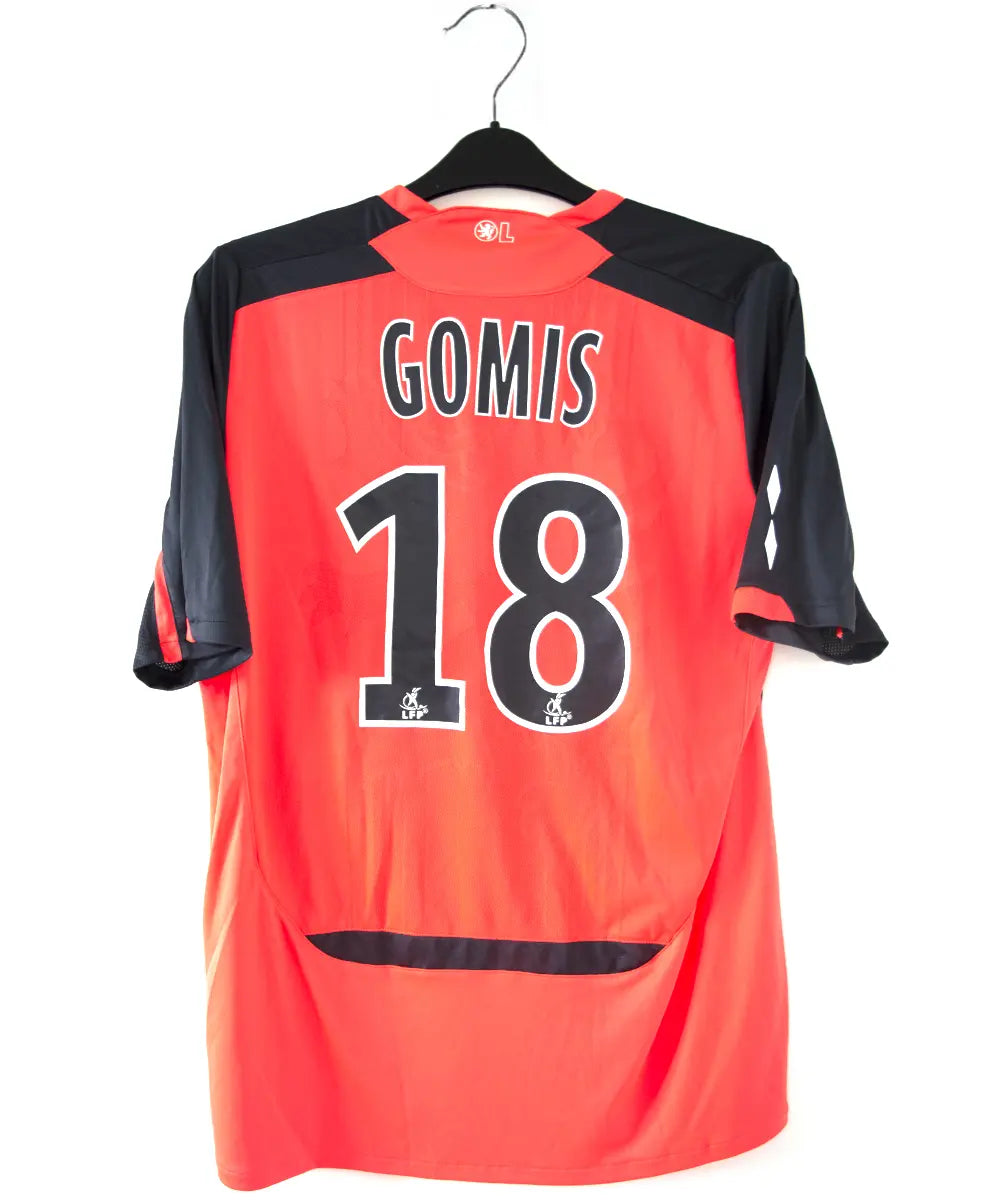 Maillot extérieur orange et noir de l'olympique lyonnais. On peut retrouver l'équipementier umbro et le sponsor apicil. Le maillot est floqué du numéro 18 Gomis