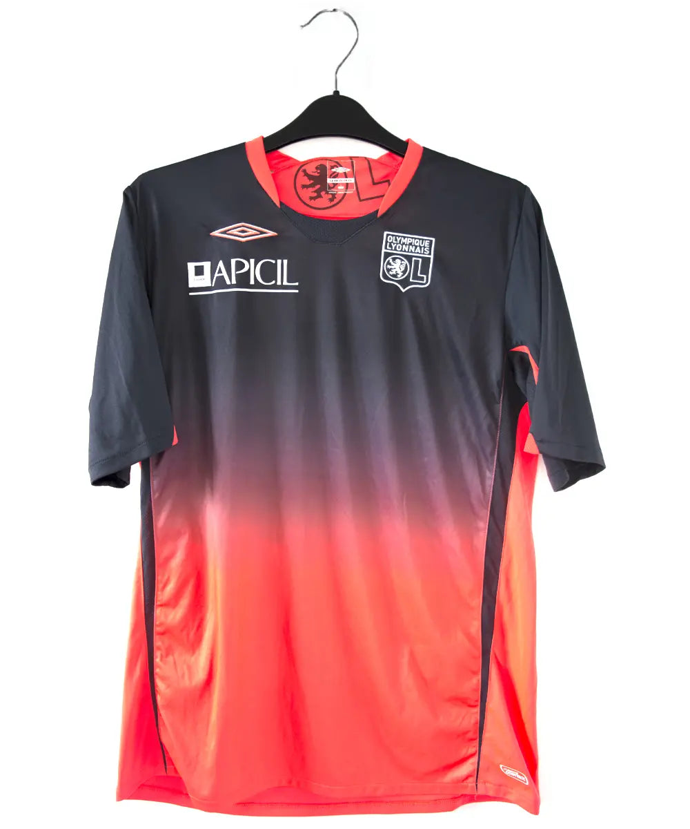 Maillot extérieur orange et noir de l'olympique lyonnais. On peut retrouver l'équipementier umbro et le sponsor apicil. Le maillot est floqué du numéro 18 Gomis