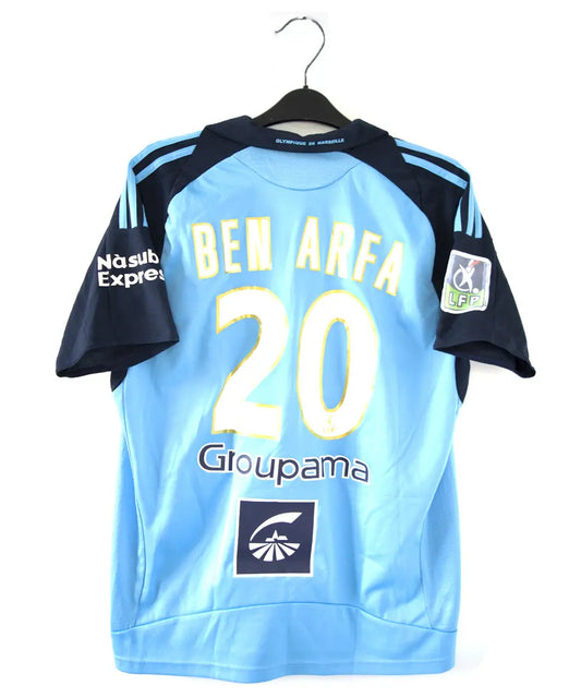 Maillot extérieur bleu clair et bleu foncé de l'om de la saison 2008-2009. Le maillot est floqué du numéro 20 Ben Arfa. On peut retrouver sur le maillot, l'équipementier adidas, le sponsor neuf, le sponsor nasuba et le sponsor groupama
