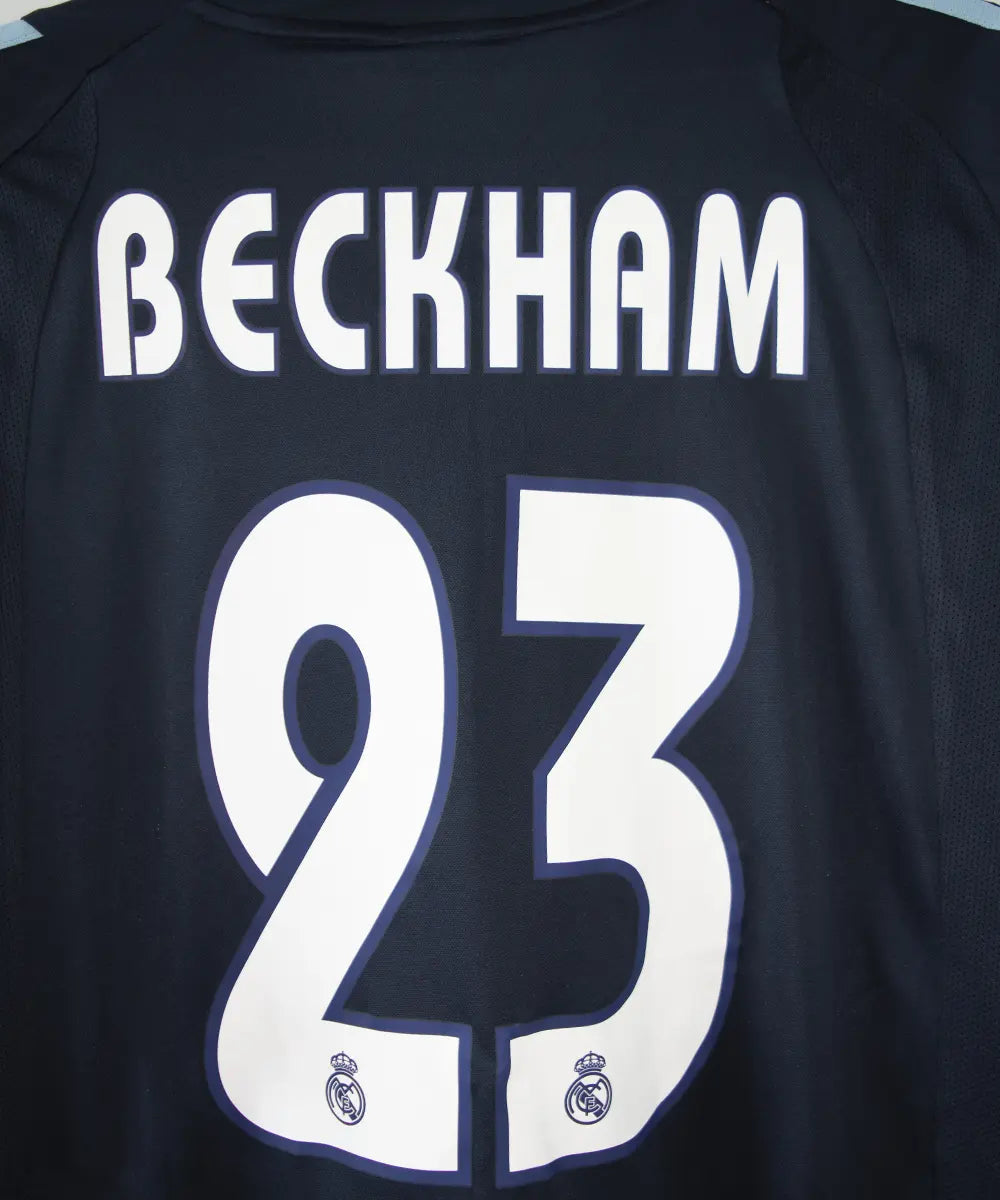 Maillot de foot vintage noir et bleu du real madrid de la saison 2003-2004. On peut retrouver l'équipementier adidas et le sponsor siemens mobile. Le maillot est floqué du numéro 23 Beckham. Il s'agit d'un maillot authentique.