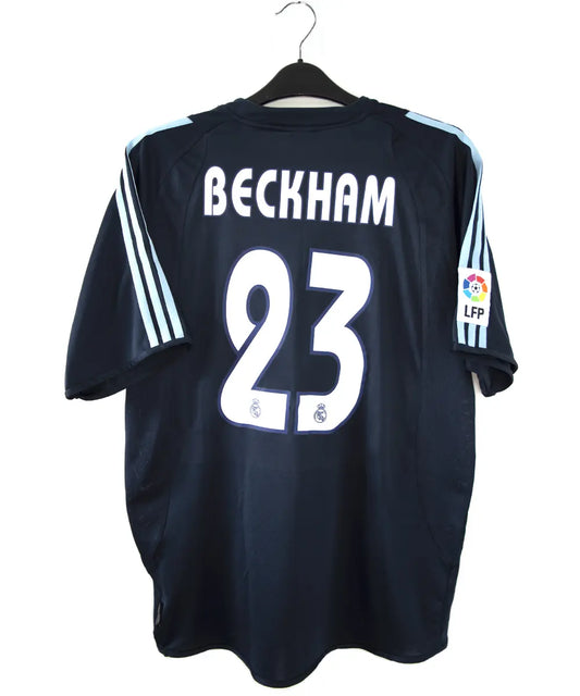 Maillot de foot vintage noir et bleu du real madrid de la saison 2003-2004. On peut retrouver l'équipementier adidas et le sponsor siemens mobile. Le maillot est floqué du numéro 23 Beckham. Il s'agit d'un maillot authentique.