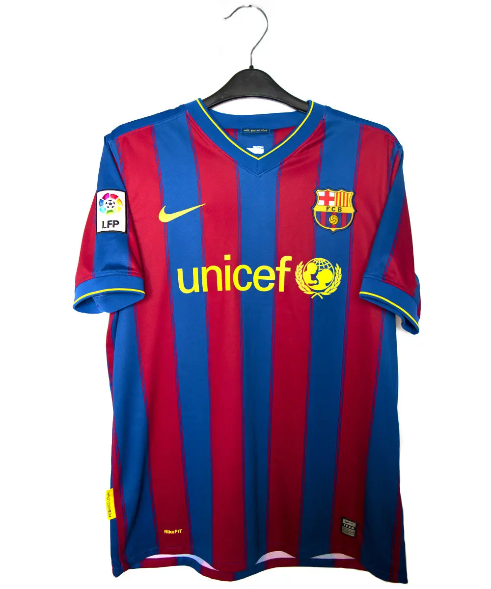 Maillot domicile du barca de la saison 2009-2010. Le maillot est de couleur bleu et rouge. On peut retrouver l'équipementier nike et le sponsor unicef.