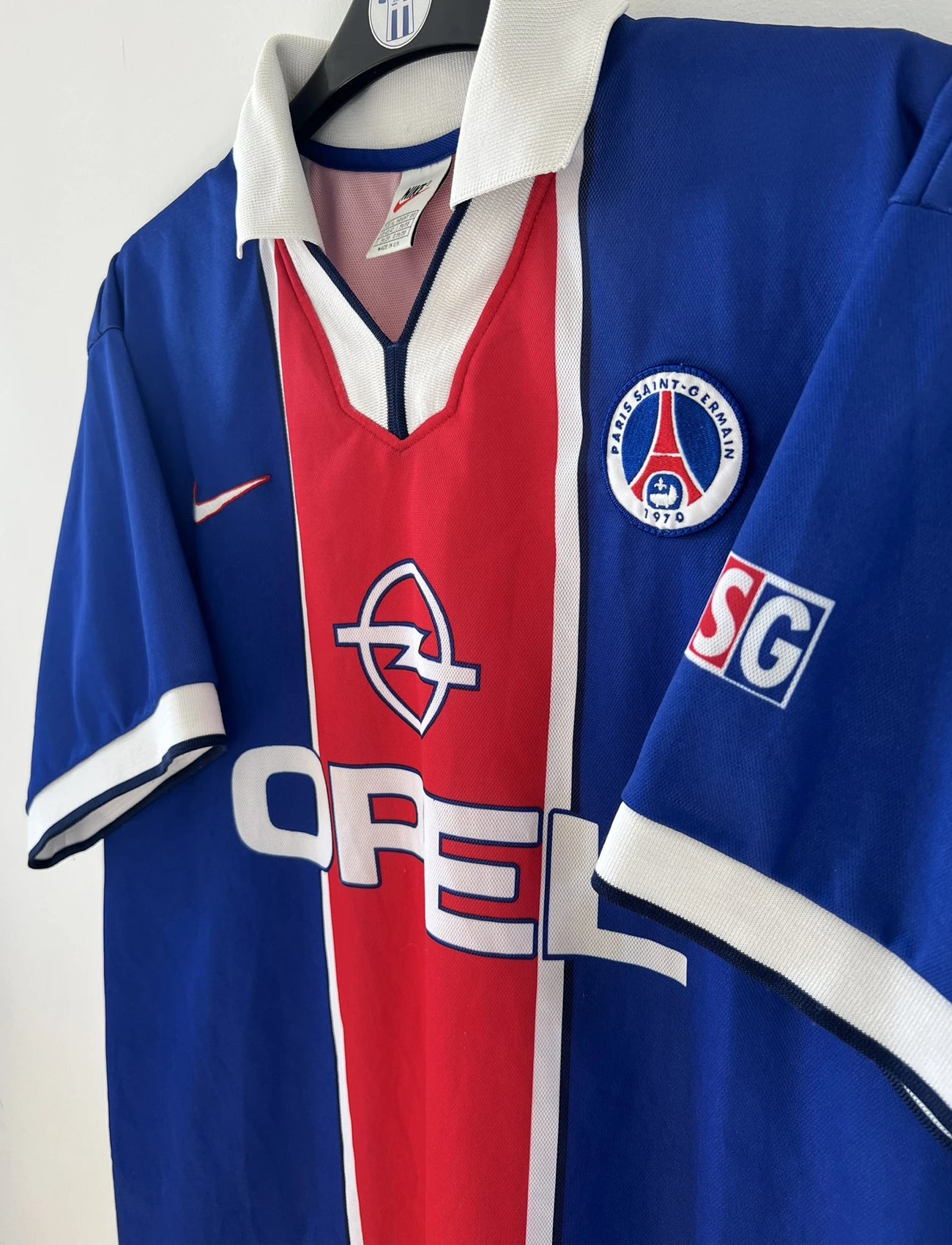 Maillot de foot vintage bleu blanc et rouge du PSG de la saison 1997/1998. On peut retrouver l'équipementier nike et le sponsor Opel. Il s'agit d'un maillot authentique.