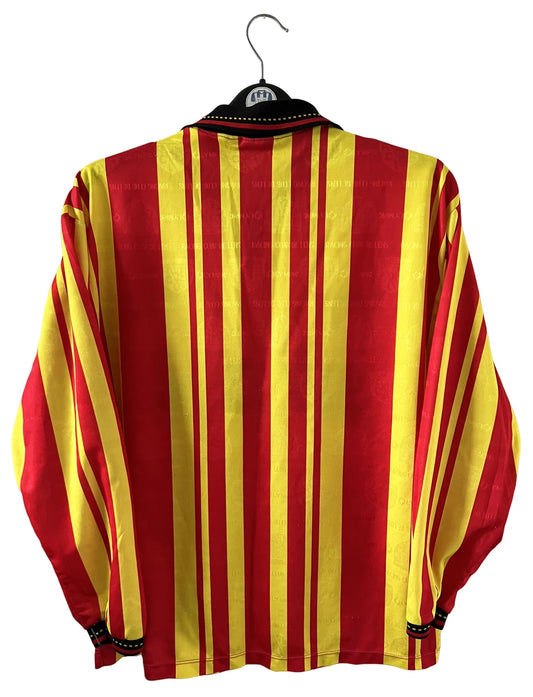 Maillot de foot vintage manches longues rouge et jaune du RC Lens 1994/1995. On peut retrouver l'équipementier Olympic et le sponsor Shopi. Il s'agit d'un maillot authentique d'époque.