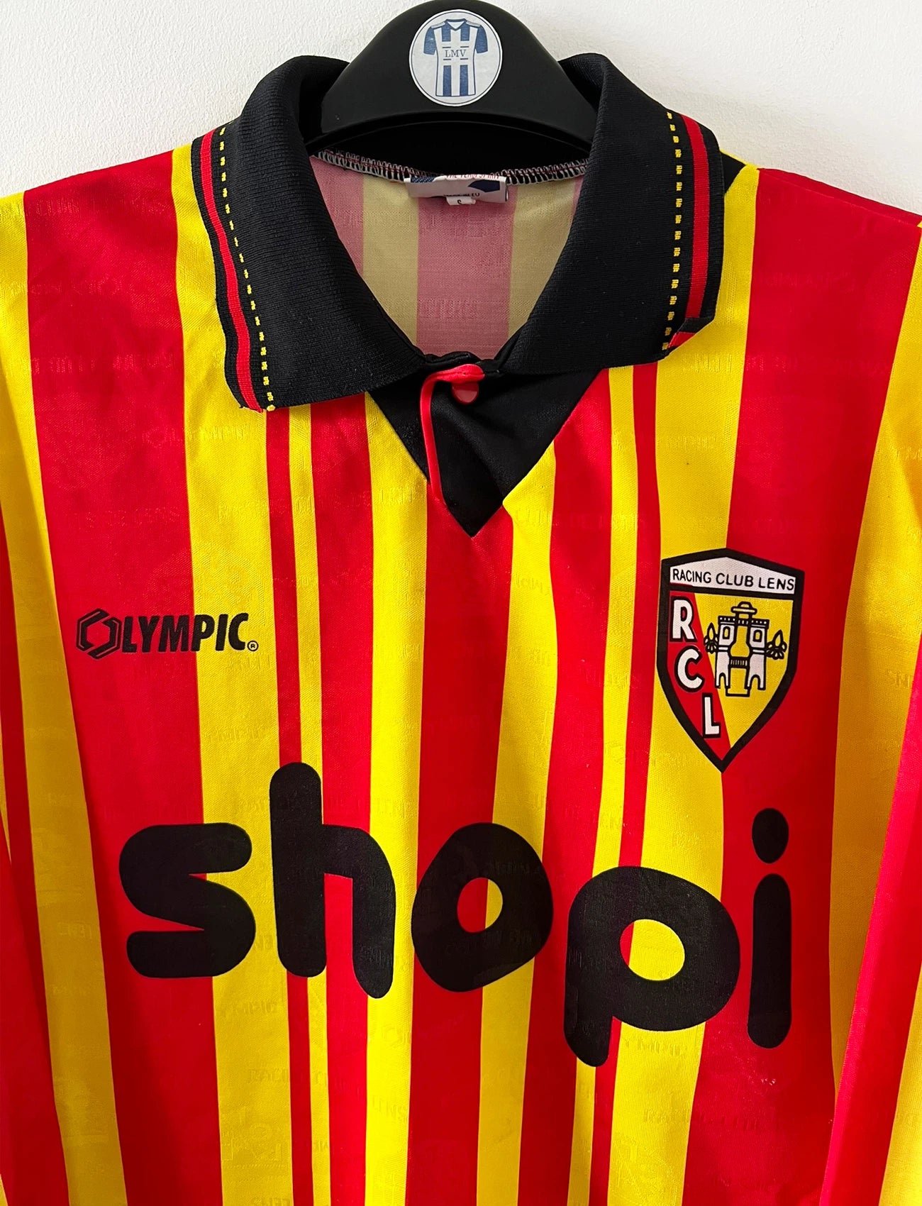 Maillot de foot vintage manches longues rouge et jaune du RC Lens 1994/1995. On peut retrouver l'équipementier Olympic et le sponsor Shopi. Il s'agit d'un maillot authentique d'époque.