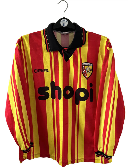 Maillot de foot vintage manches longues rouge et jaune du RC Lens 1994/1995. On peut retrouver l'équipementier Olympic et le sponsor Shopi. Il s'agit d'un maillot authentique d'époque.