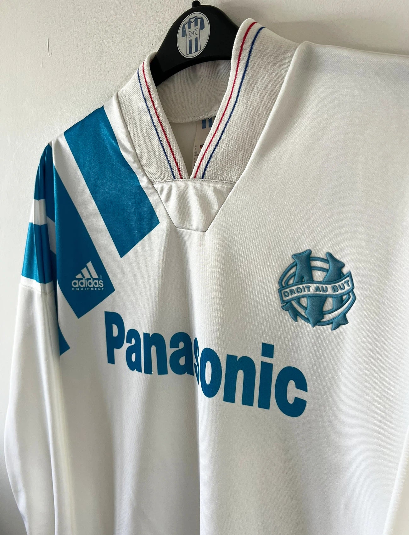 Maillot de foot vintage domicile blanc de l'OM 1992/1993. On peut retrouver l'équipementier Adidas et le sponsor Panasonic. Il s'agit d'un maillot authentique d'époque.