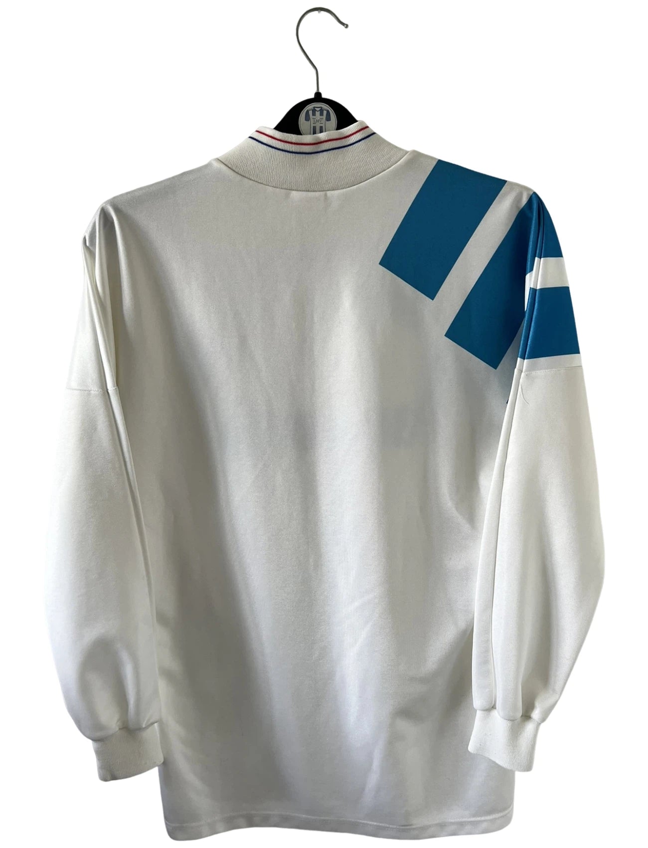 Maillot de foot vintage domicile blanc de l'OM 1992/1993. On peut retrouver l'équipementier Adidas et le sponsor Panasonic. Il s'agit d'un maillot authentique d'époque.