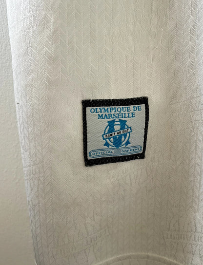 Maillot de foot vintage domicile blanc de l'OM 1996/1997. On peut retrouver l'équipementier Adidas et le sponsor Parmalat. Il s'agit d'un maillot authentique d'époque.
