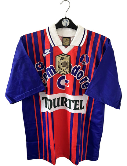 Maillot de foot vintage domicile rouge et bleu du PSG 1993/1994. On peut retrouver l'équipementier Nike et les sponsors Tourtel et commodore. Il s'agit d'un maillot authentique d'époque.