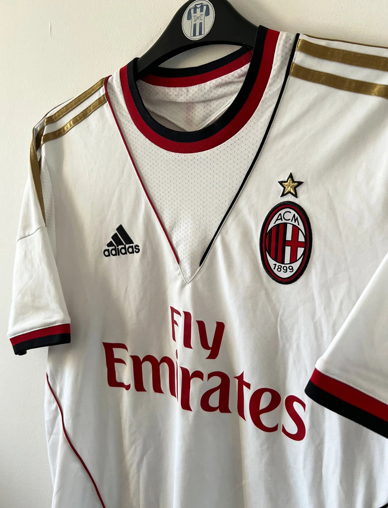 Maillot de foot vintage extérieur blanc de l'AC Milan 2013-2014. On peut retrouver l'équipementier Adidas et le sponsor Fly Emirates. Le maillot est floqué du numéro 22 Kaka. Il s'agit d'un maillot authentique d'époque.