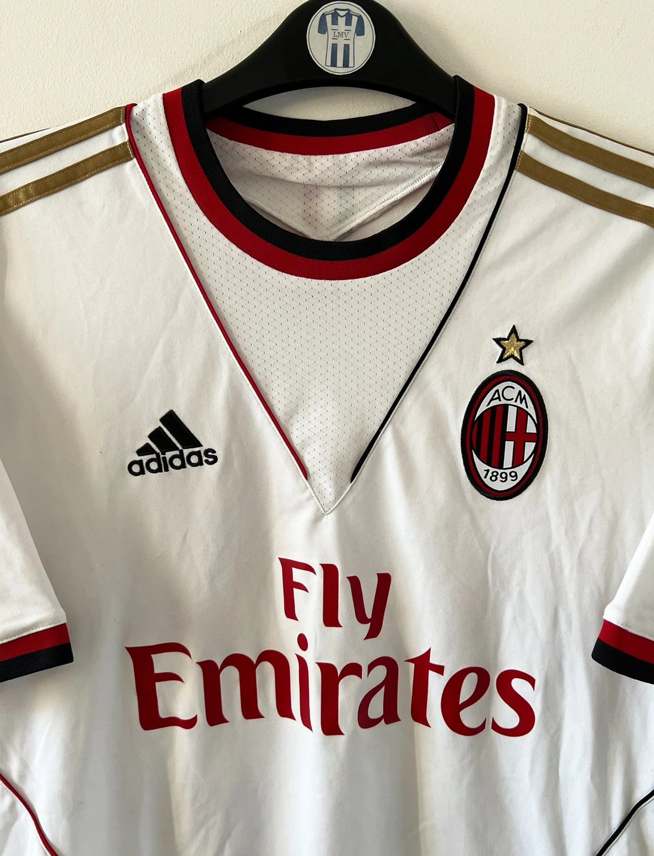 Maillot de foot vintage extérieur blanc de l'AC Milan 2013-2014. On peut retrouver l'équipementier Adidas et le sponsor Fly Emirates. Le maillot est floqué du numéro 22 Kaka. Il s'agit d'un maillot authentique d'époque.