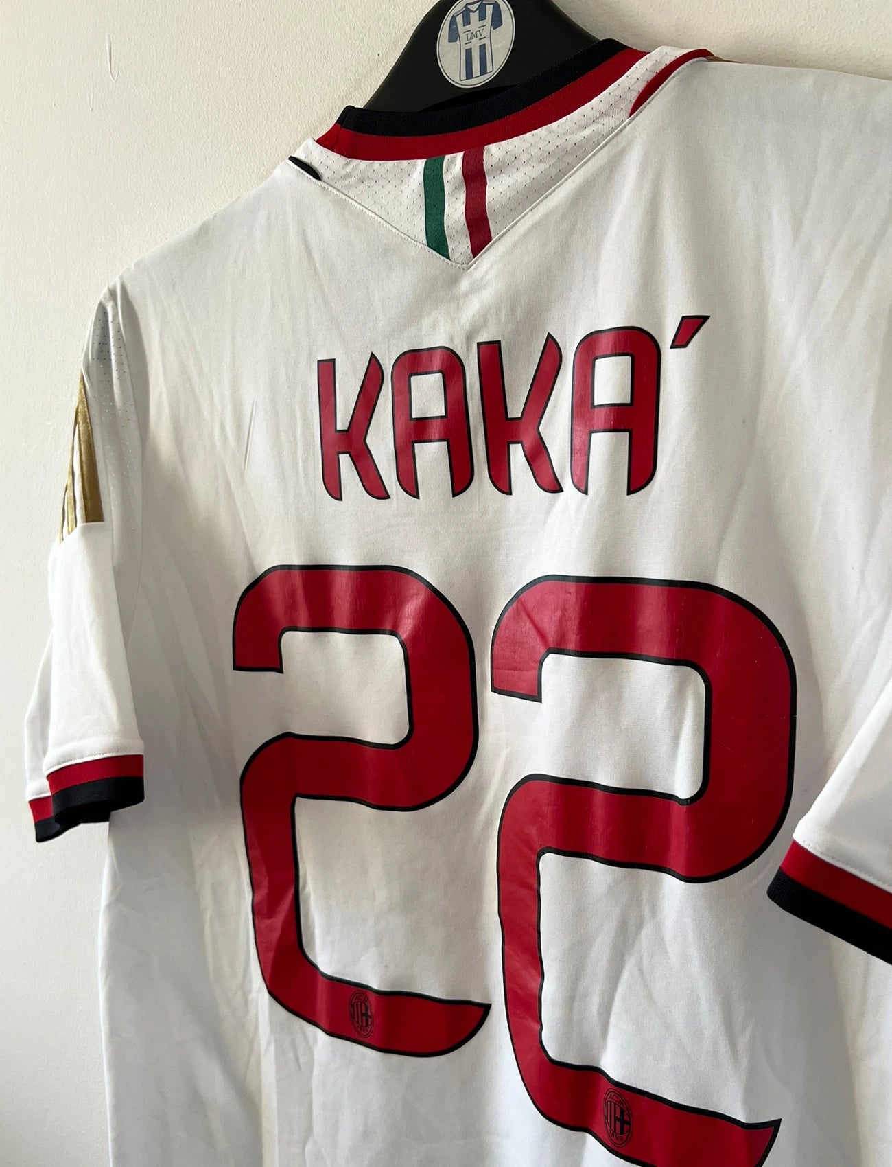 Maillot de foot vintage extérieur blanc de l'AC Milan 2013-2014. On peut retrouver l'équipementier Adidas et le sponsor Fly Emirates. Le maillot est floqué du numéro 22 Kaka. Il s'agit d'un maillot authentique d'époque.
