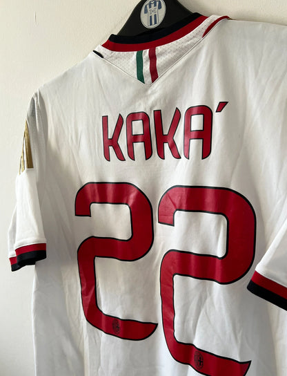 Maillot de foot vintage extérieur blanc de l'AC Milan 2013-2014. On peut retrouver l'équipementier Adidas et le sponsor Fly Emirates. Le maillot est floqué du numéro 22 Kaka. Il s'agit d'un maillot authentique d'époque.