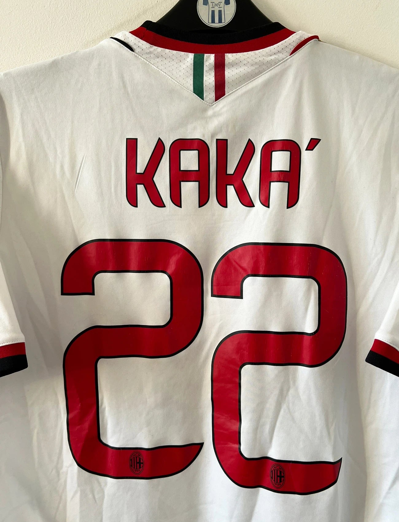 Maillot de foot vintage extérieur blanc de l'AC Milan 2013-2014. On peut retrouver l'équipementier Adidas et le sponsor Fly Emirates. Le maillot est floqué du numéro 22 Kaka. Il s'agit d'un maillot authentique d'époque.