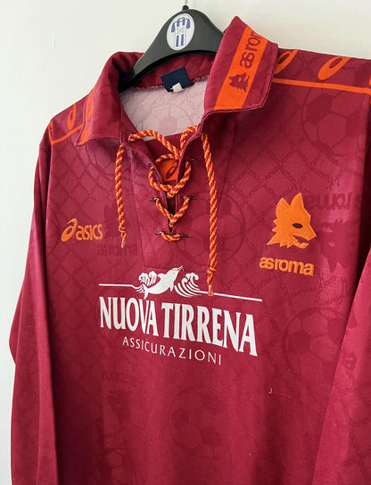 Maillot de foot vintage de l'AS Roma de la saison 1994/1995. Le maillot est de couleur rouge et orange. On peut retrouver l'équipementier asics et le sponsor nuova tirrena. Il s'agit d'un maillot authentique d'époque.