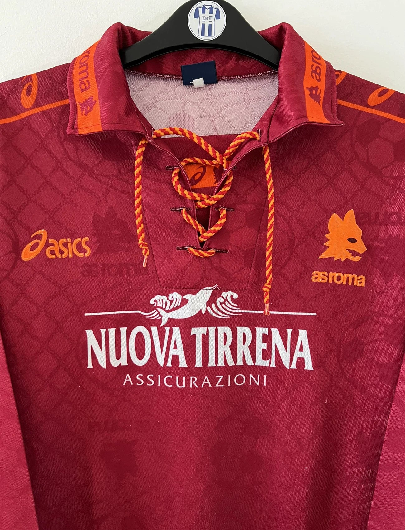 Maillot de foot vintage de l'AS Roma de la saison 1994/1995. Le maillot est de couleur rouge et orange. On peut retrouver l'équipementier asics et le sponsor nuova tirrena. Il s'agit d'un maillot authentique d'époque.