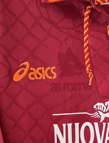 Maillot de foot vintage de l'AS Roma de la saison 1994/1995. Le maillot est de couleur rouge et orange. On peut retrouver l'équipementier asics et le sponsor nuova tirrena. Il s'agit d'un maillot authentique d'époque.