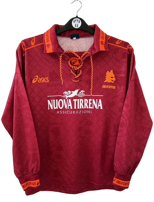 Maillot de foot vintage de l'AS Roma de la saison 1994/1995. Le maillot est de couleur rouge et orange. On peut retrouver l'équipementier asics et le sponsor nuova tirrena. Il s'agit d'un maillot authentique d'époque.