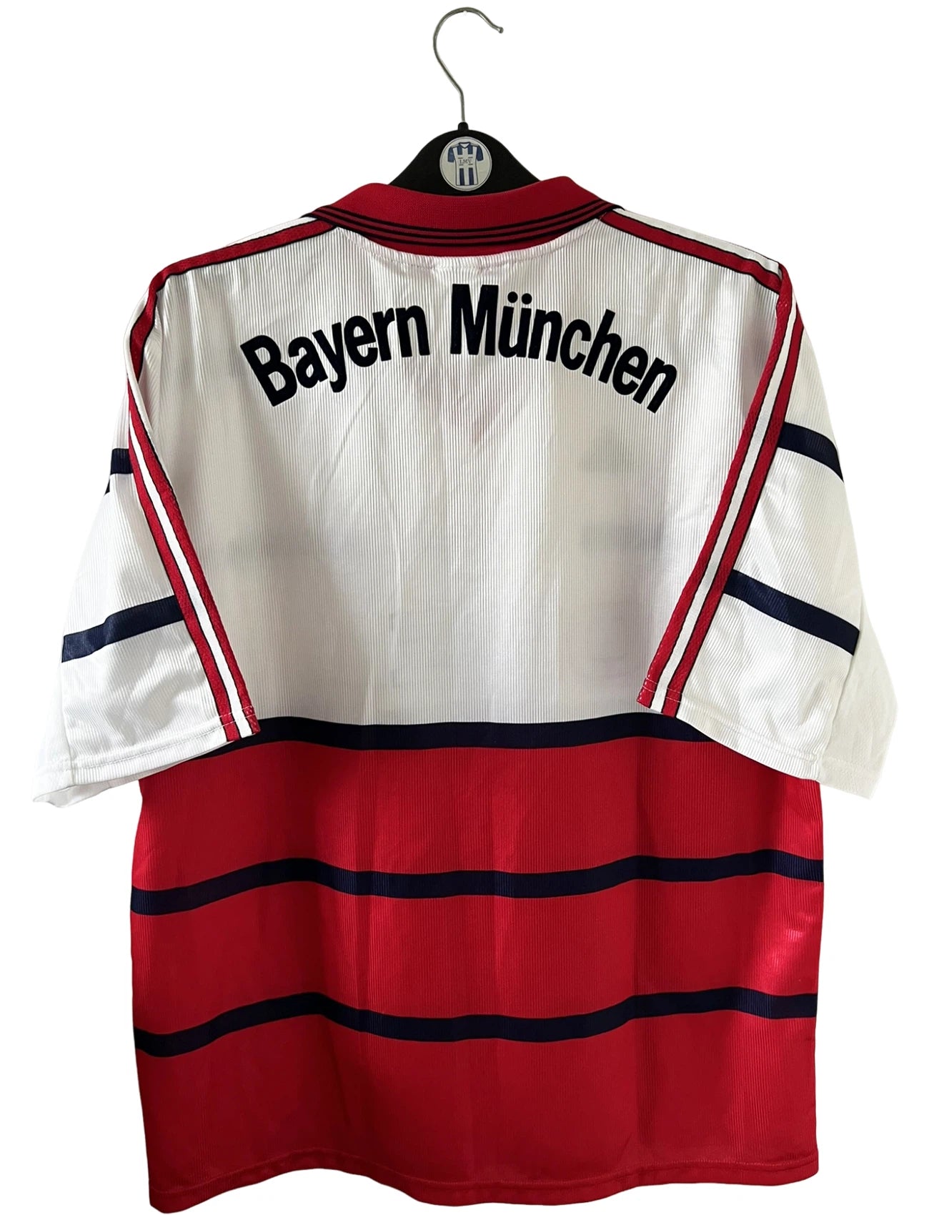Maillot de foot vintage extérieur blanc et rouge du Bayern Munich 1998/2000. On peut retrouver l'équipementier Adidas et le sponsor Opel. Il s'agit d'un maillot authentique d'époque.