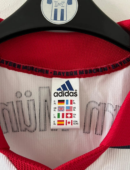 Maillot de foot vintage extérieur blanc et rouge du Bayern Munich 1998/2000. On peut retrouver l'équipementier Adidas et le sponsor Opel. Il s'agit d'un maillot authentique d'époque.