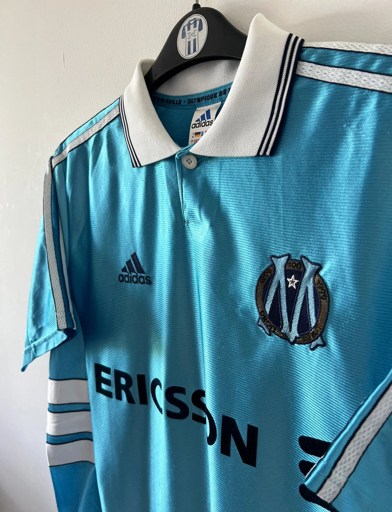 Maillot de foot vintage extérieur bleu de l'OM 1998/1999. On peut retrouver l'équipementier Adidas et le sponsor Ericsson. Il s'agit d'un maillot authentique d'époque.