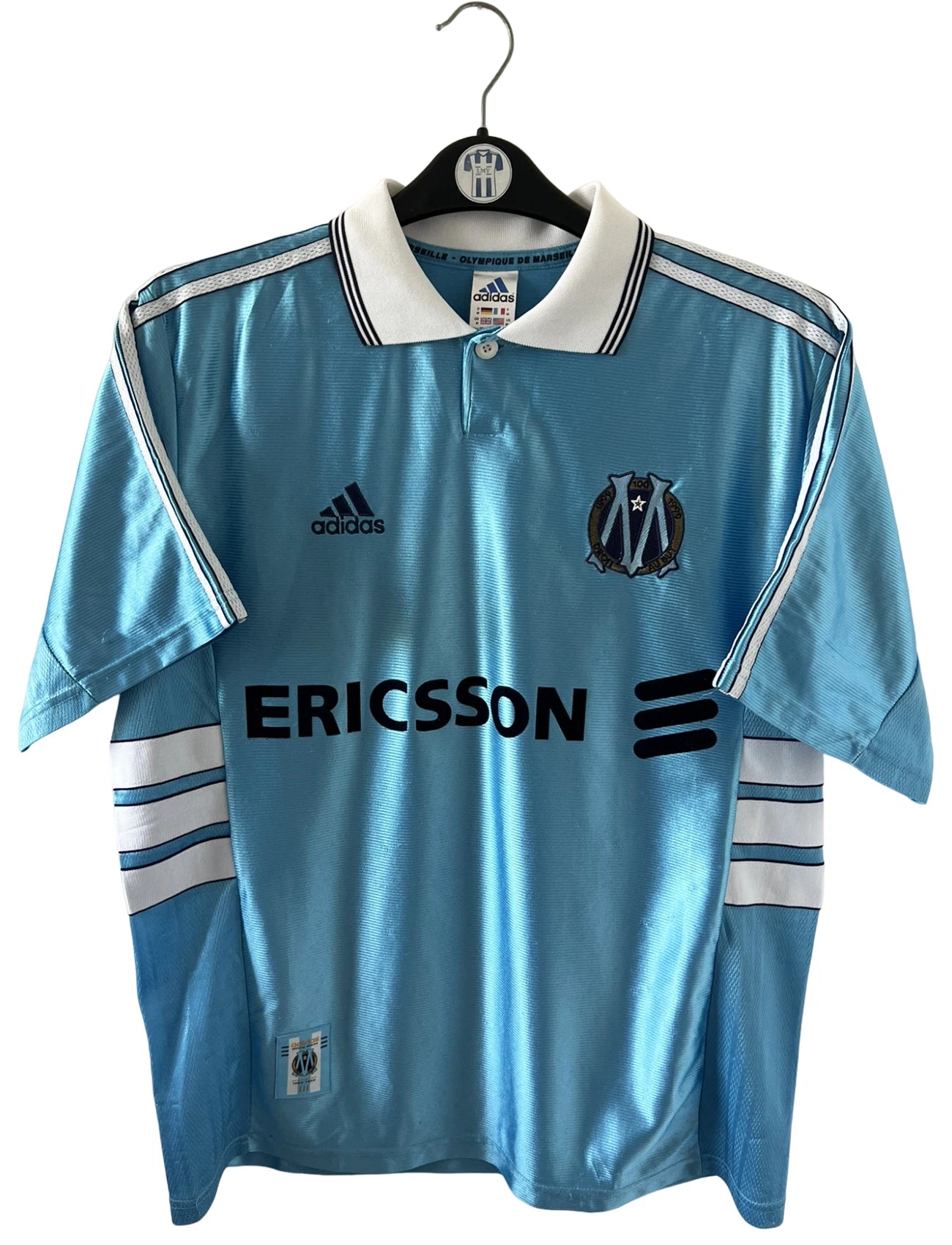Maillot de foot vintage extérieur bleu de l'OM 1998/1999. On peut retrouver l'équipementier Adidas et le sponsor Ericsson. Il s'agit d'un maillot authentique d'époque.