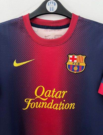 Maillot de foot vintage domicile rouge et bleu du FC Barcelone 2012/2013. On peut retrouver l'équipementier Nike et le sponsor Qatar Foundation. Le maillot est floqué du numéro 8 Andrés Iniesta. Il s'agit d'un maillot authentique d'époque.