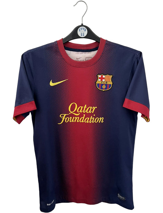 Maillot de foot vintage domicile rouge et bleu du FC Barcelone 2012/2013. On peut retrouver l'équipementier Nike et le sponsor Qatar Foundation. Le maillot est floqué du numéro 8 Andrés Iniesta. Il s'agit d'un maillot authentique d'époque.