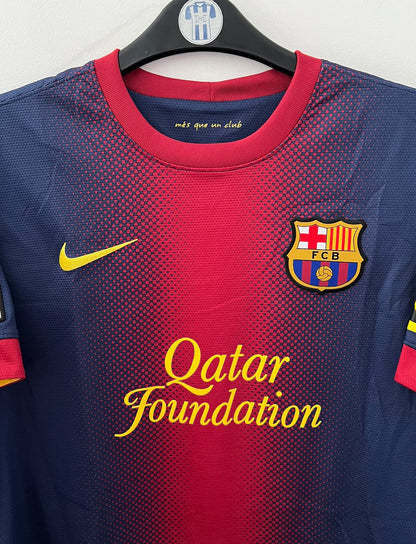 Maillot de foot vintage domicile rouge et bleu du FC Barcelone 2012/2013. On peut retrouver l'équipementier Nike et le sponsor Qatar Foundation. Le maillot est floqué du numéro 10 Lionel Messi. Il s'agit d'un maillot authentique d'époque.