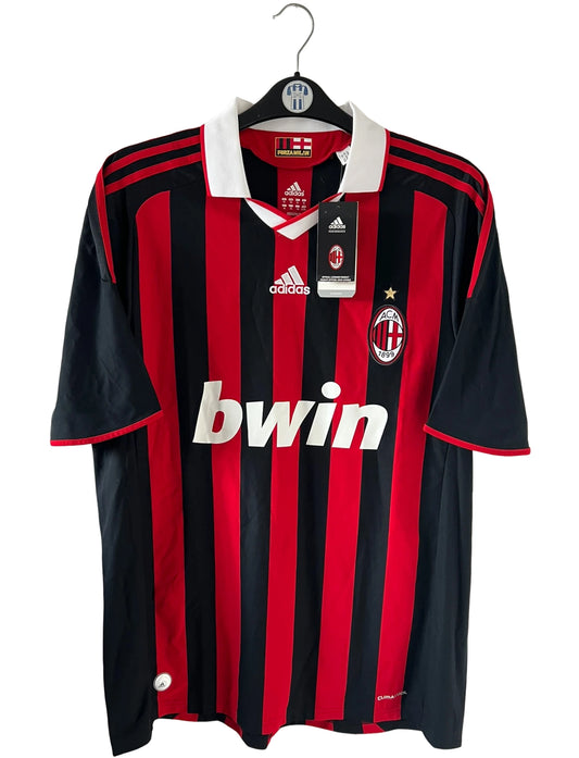Maillot de foot vintage domicile rouge et noir de l'AC Milan saison 2009/2010. On peut retrouver l'équipementier Adidas et le sponsor Bwin. Il s'agit d'un maillot authentique d'époque.