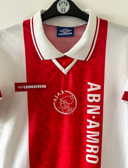 Maillot de foot vintage domicile rouge et blanc de l'Ajax Amsterdam de la saison 1998/1999. On peut retrouver l'équipementier Umbro et le sponsor ABN AMRO. Il s'agit d'un maillot authentique d'époque.
