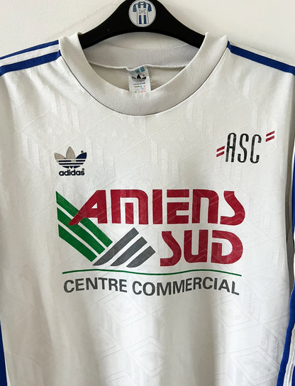 Maillot de foot vintage domicile blanc de l'Amiens SC 1989/1990. On peut retrouver l'équipementier Adidas et le sponsor Amiens Sud. Il s'agit d'un maillot authentique d'époque.