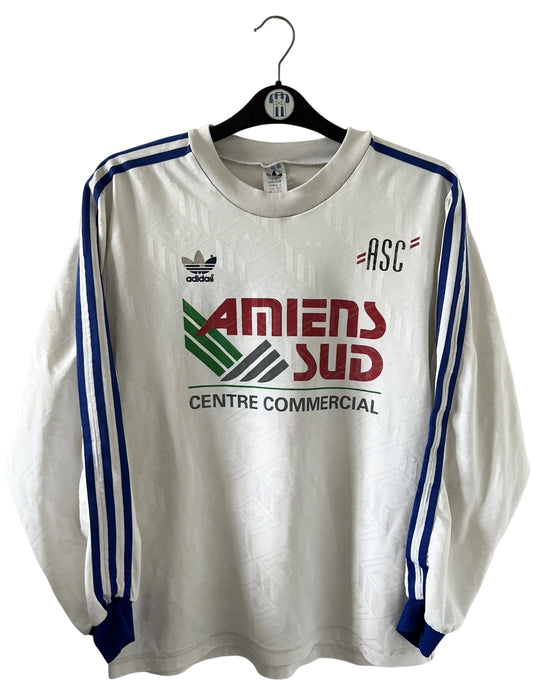 Maillot de foot vintage domicile blanc de l'Amiens SC 1989/1990. On peut retrouver l'équipementier Adidas et le sponsor Amiens Sud. Il s'agit d'un maillot authentique d'époque.