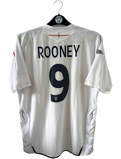 Maillot de foot vintage domicile blanc de l'Angleterre de la saison 2008-2009. On peut y retrouver l'équipementier Umbro. Le maillot est floqué du numéro 9 Rooney. Il s'agit d'un maillot authentique d'époque