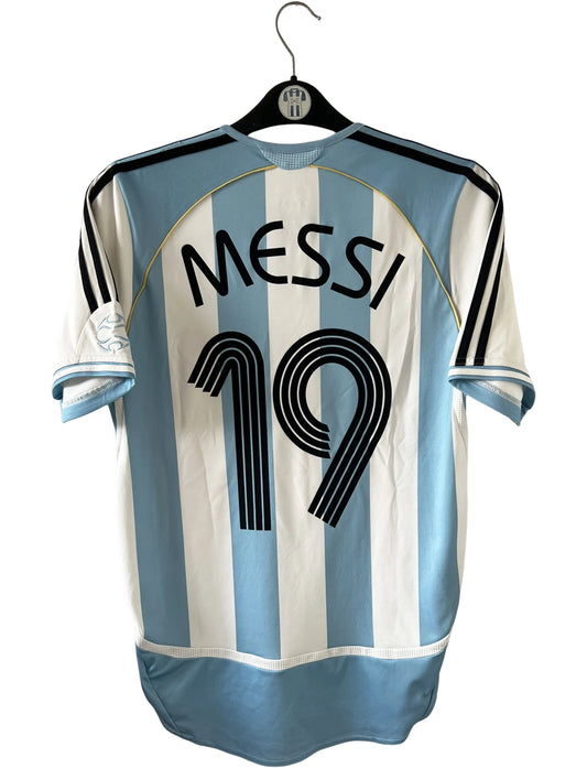Maillot de foot vintage domicile de l'Argentine 2006. On peut retrouver l'équipementier Adidas. Le maillot est floqué du numéro 19 Messi. Il s'agit d'un maillot authentique d'époque.