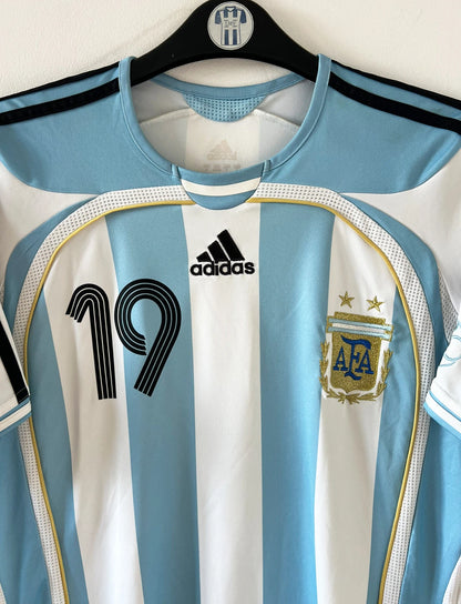 Maillot de foot vintage domicile de l'Argentine 2006. On peut retrouver l'équipementier Adidas. Le maillot est floqué du numéro 19 Messi. Il s'agit d'un maillot authentique d'époque.
