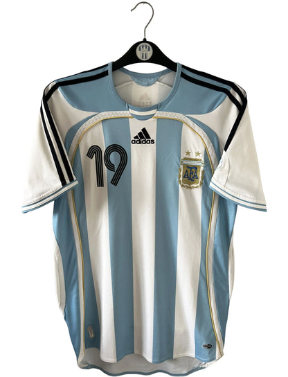 Maillot de foot vintage domicile de l'Argentine 2006. On peut retrouver l'équipementier Adidas. Le maillot est floqué du numéro 19 Messi. Il s'agit d'un maillot authentique d'époque.