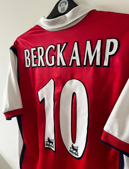 Maillot de foot vintage domicile rouge et blanc d'arsenal de la saison 1998/1999. On peut retrouver l'équipementier Nike et le sponsor JVC. Le maillot est floqué du numéro 10 Dennis Bergkamp. Il s'agit d'un maillot authentique d'époque.
