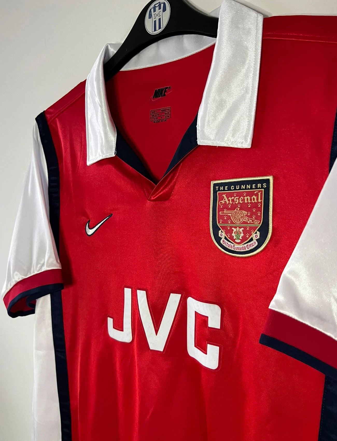 Maillot de foot vintage domicile rouge et blanc d'Arsenal de la saison 1998/1999. On peut retrouver l'équipementier Nike et le sponsor JVC. Il s'agit d'un maillot authentique d'époque.