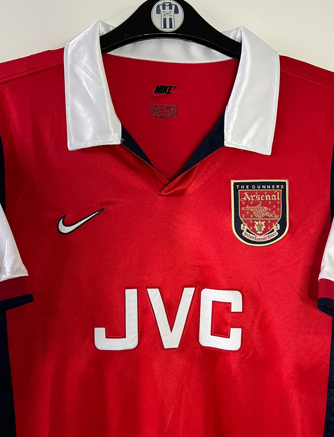 Maillot de foot vintage domicile rouge et blanc d'Arsenal de la saison 1998/1999. On peut retrouver l'équipementier Nike et le sponsor JVC. Il s'agit d'un maillot authentique d'époque.