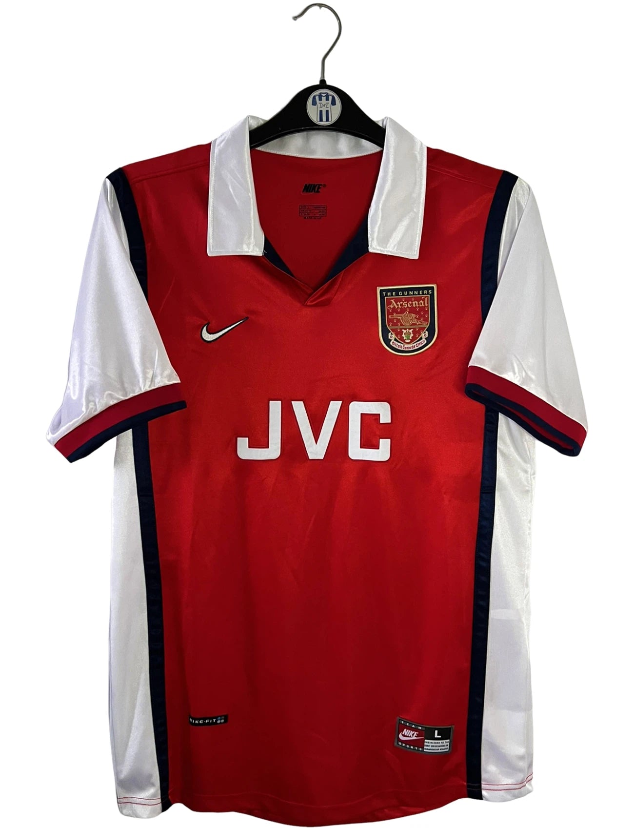 Maillot de foot vintage domicile rouge et blanc d'Arsenal de la saison 1998/1999. On peut retrouver l'équipementier Nike et le sponsor JVC. Il s'agit d'un maillot authentique d'époque.
